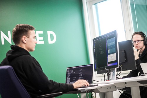 Two employees working at screens at an office
